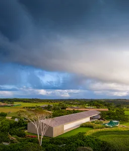 A modern residence with a concrete roof surrounded by lush greenery.
