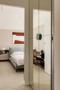 A modern minimalist bedroom featuring neutral tones and simple design.