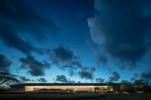 Modern building with large glass windows at dusk.