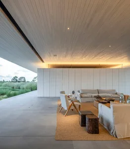 Modern living room with a contemporary design, featuring concrete flooring and minimalist furniture.