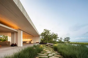 A modern residential exterior featuring concrete and wooden elements.