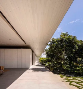 Modern minimalist architectural design featuring a concrete exterior and wooden columns.