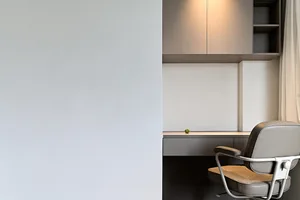 A minimalist workspace featuring a concrete desk and chair.