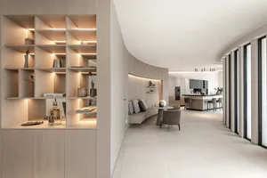 A modern living room featuring light wooden furniture and marble accents.