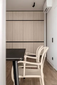 Modern minimalist dining room with wooden furniture and a sleek, dark dining table.