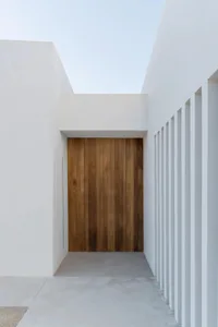 A minimalist entryway with a wooden door.