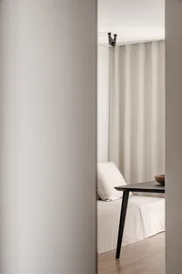 A minimalist interior design with neutral colors and a simple black table.