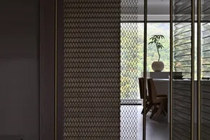 A modern interior space featuring a wooden trellis structure and a vase with greenery on a table.