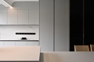 A modern kitchen featuring a marble countertop and minimalist cabinetry.