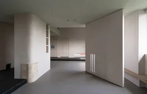 A minimalist kitchen featuring concrete walls and flooring.