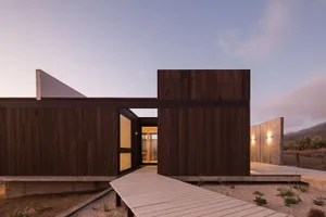 Modern minimalist residential exterior featuring wooden and concrete materials.