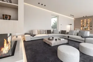 Modern living room with curved sofas, neutral-tones, and elegant decor.