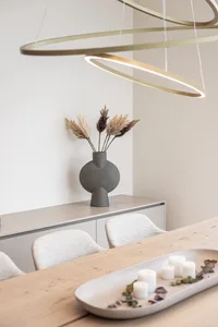 Modern dining room featuring a sleek wooden table, minimalist decor, and contemporary lighting.
