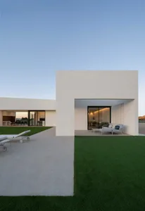 Modern minimalist residential exterior with concrete, glass, and steel materials.