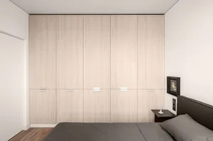 A minimalist bedroom featuring light-colored wooden flooring and furniture against white walls, showcasing a clean and organi