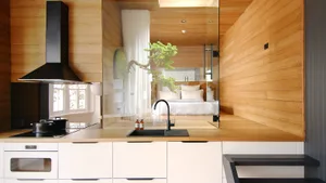 Modern minimalist kitchen with wood finishes and black appliances.