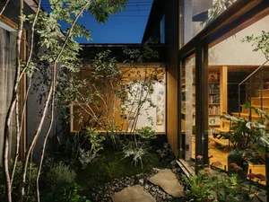 Modern residential interior featuring glass walls and wooden beams.