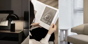 Person reading a book with a black and white photograph inside a modern interior with black and white window shades.