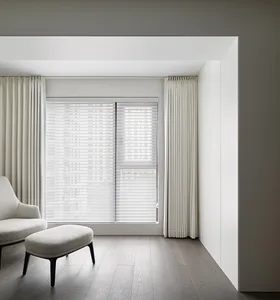 Modern neutral living room featuring a simple, minimalist design with light-colored furniture and wooden flooring.
