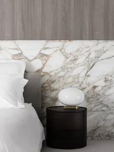 A modern marble bedroom featuring a side table with a black finish.