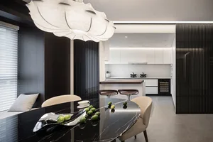 Modern kitchen with a marble countertop and black marble dining table with green limes on it.