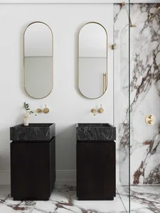 Modern minimalist bathroom with black marble sinks, brass fixtures, and marble walls and floor.