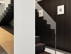 Modern minimalist staircase with black wooden steps and white walls.