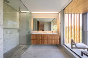 Modern bathroom with concrete walls, minimalist furniture, and large windows