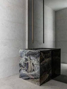 A modern, minimalist bathroom features sleek marble fixtures and a gray marble wall.