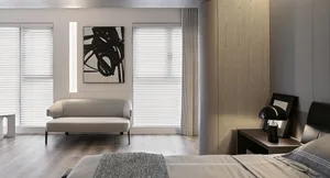 A modern living room featuring a white couch and a minimalist art piece on the wall.