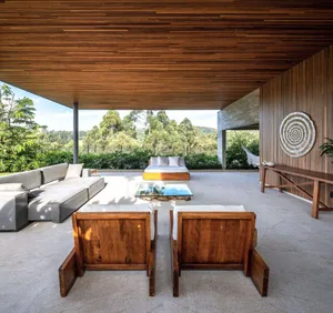 Modern outdoor living space with wood furniture and natural surroundings.