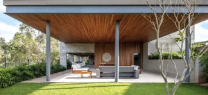 Modern living space with wooden ceiling, gray sofa, and outdoor seating area
