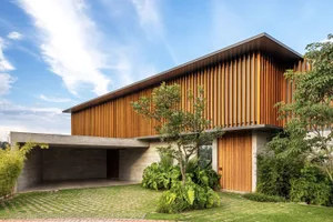 A modern residential house with a wooden facade and concrete foundation.