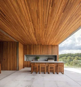 Modern residential kitchen with wooden ceiling and flooring, concrete countertops, and stainless steel appliances.