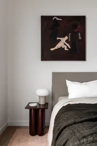 Modern minimalist bedroom featuring textured fabric and abstract art.