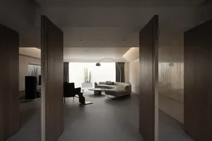 Contemporary minimalist living room with concrete floor and walls, featuring a sleek sectional sofa and a minimalist coffee t