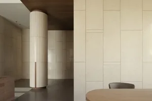 A minimalist office space featuring a natural stone wall and floor.