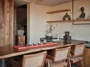 A modern home bar featuring a live edge wooden counter with tea preparation set.