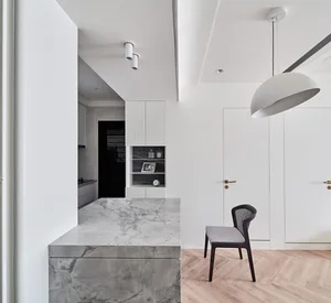 A modern, minimalist residential kitchen with a marble countertop.