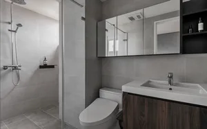 Modern bathroom featuring ceramic tiles, a walk-in shower, a toilet, a white sink with a dark wooden cabinet, and a large mir