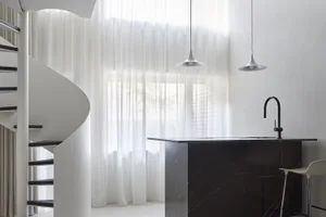 Modern minimalist kitchen with marble countertop and pendant lights.