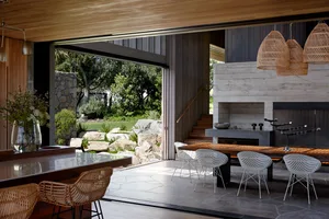 A modern living room with concrete walls, a fireplace, and white chairs.