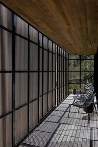 A modern patio with wooden grid panels and a wooden ceiling.