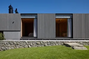 Modern residential house featuring a contemporary design with metal cladding exterior and large windows.