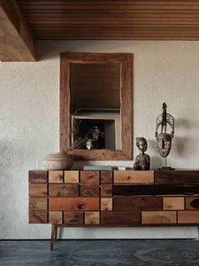 A stylish wooden sideboard featuring an industrial mask and a vase.
