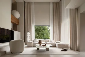 Modern minimalist living room featuring neutral tones, a comfortable sectional sofa, and a large window with curtains.