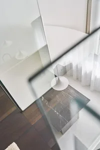 A modern interior design featuring a glass floor with a dark wood grain pattern.
