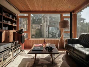 A modern living room with wood features and large windows showing a city view.