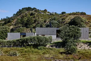A modern residential building with metallic and stone exterior materials.