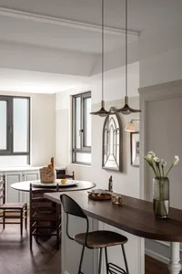 A modern rustic kitchen featuring wooden counters and island, glass cabinet doors, and metal accents